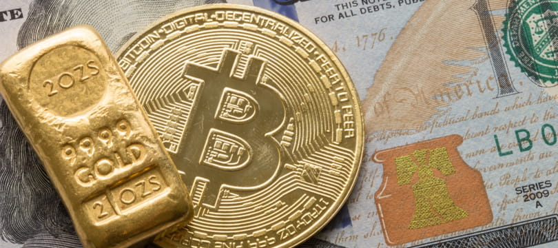 Gold bars beside a physical bitcoin, comparing the two store-of-value assets