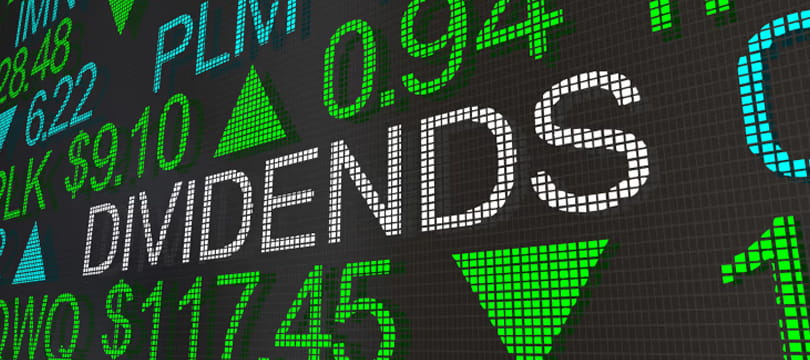 Stock ticker board displaying the word dividends among green and red quotes