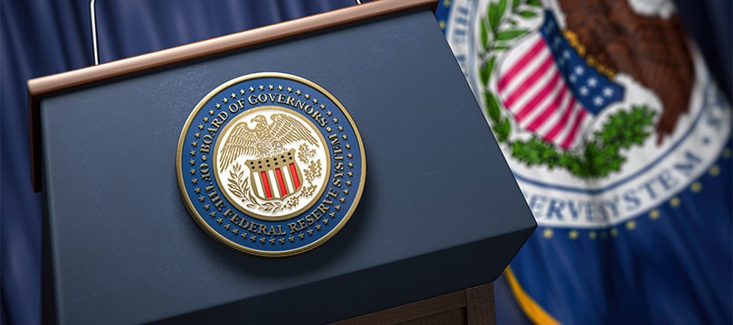 Federal Reserve seal beside the US flag, symbol of central bank interest rate policy